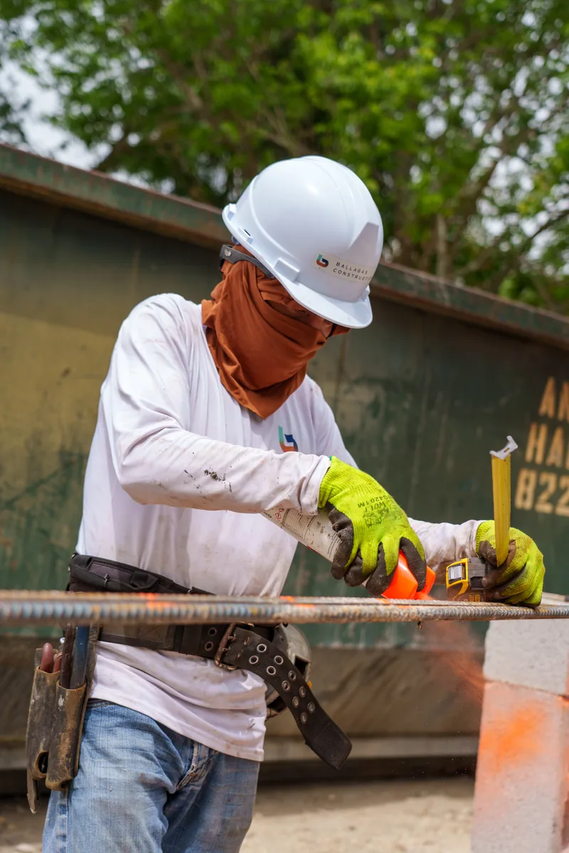 Crew member measuring and cutting reinforcing bar at the Kaēlo Residence, Miami Shores